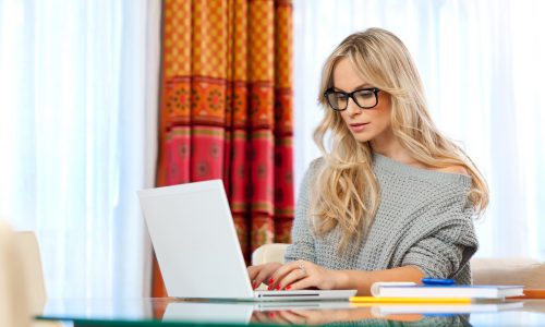 attractive woman writer in her home with laptop in creative process Recenzja SEO Playbook - zdjęcie nr 11