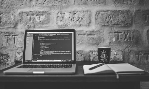 grayscale-photo-of-computer-laptop-near-white-notebook-and-169573 meta description